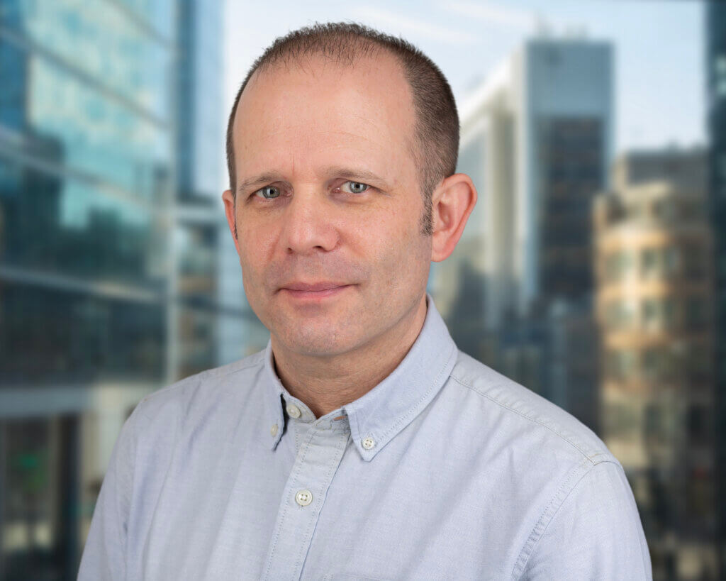 Image of Ben Holloway, the Founder of Holloway Consulting, standing in front of a London skyline.